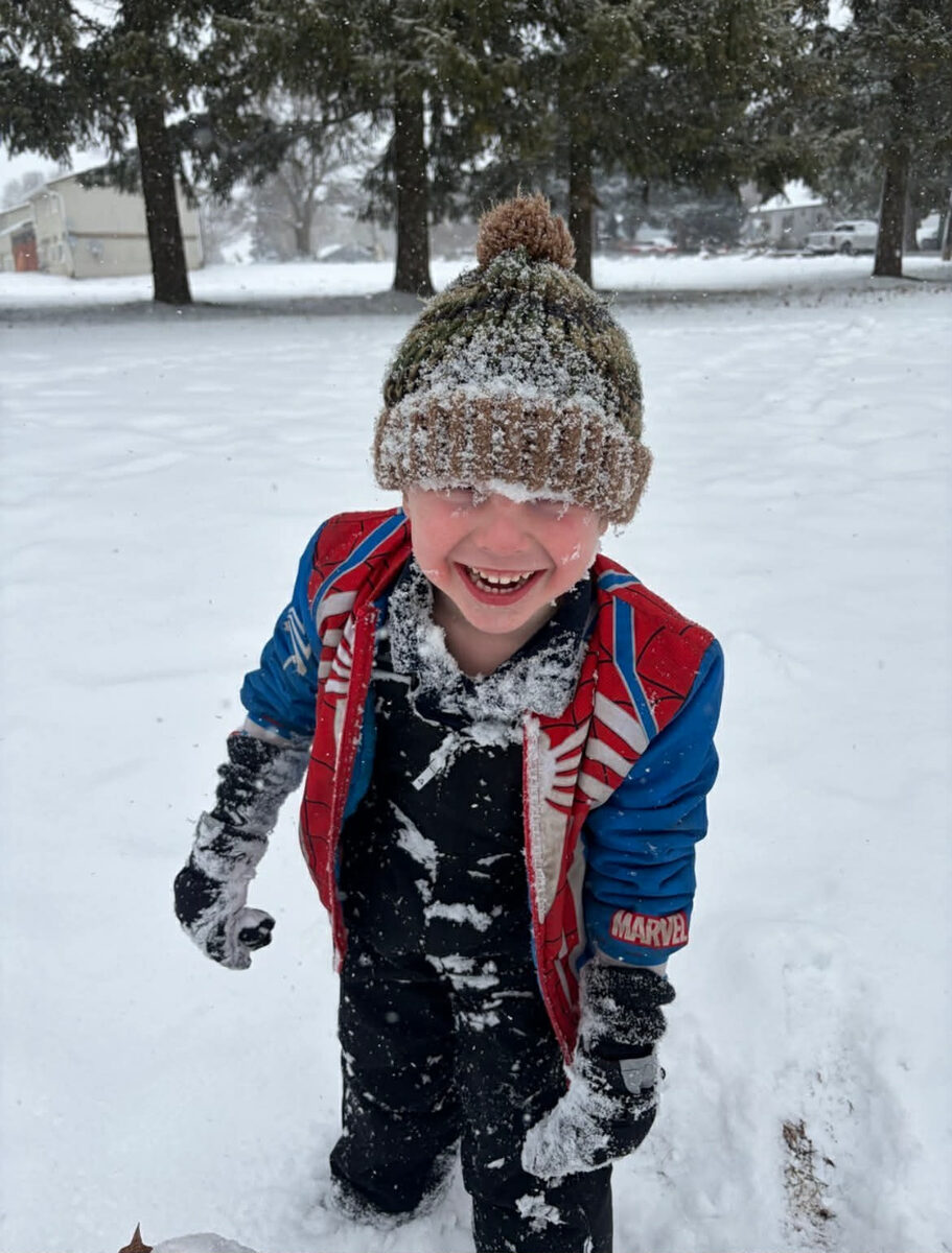 Student joyfully playing in the snow