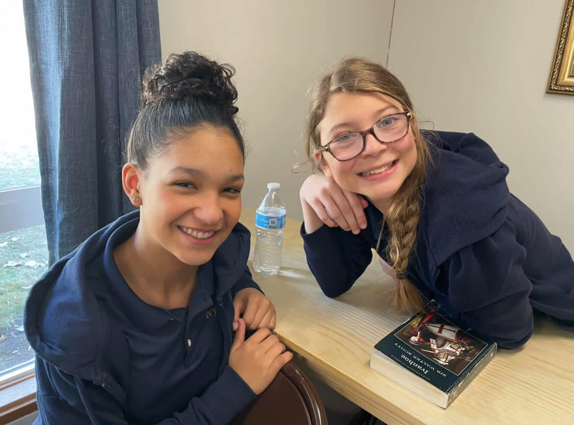 Two students reading together at a table