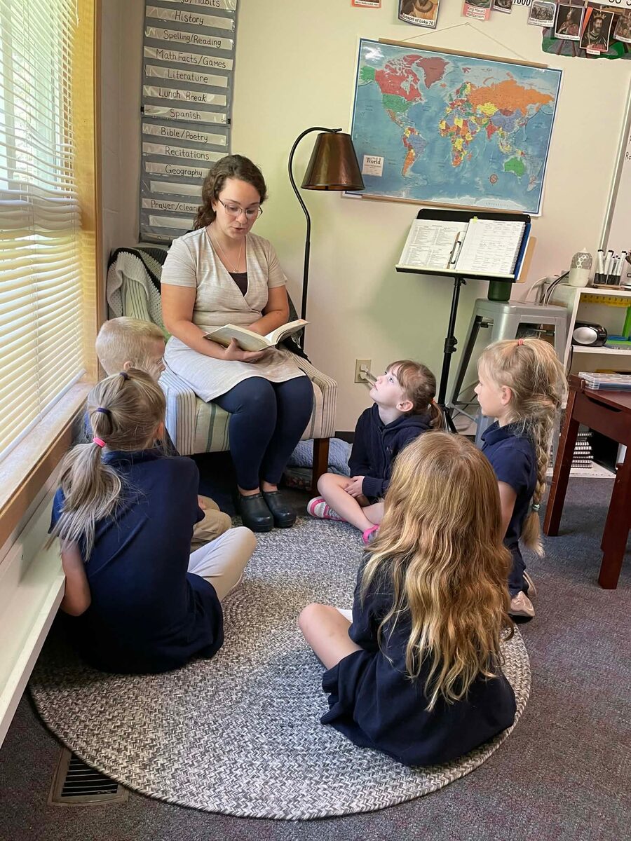 Teacher reading aloud to young students